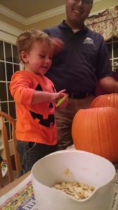 The little guy gets his hands dirty helping with the pumpkin carving!